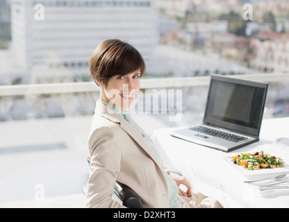 Portrait of smiling businesswoman avec déjeuner à 24 Banque D'Images