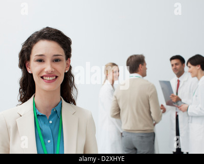 Portrait of smiling businesswoman avec les médecins en arrière-plan Banque D'Images