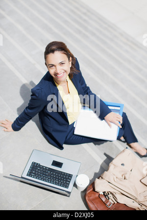 Portrait of smiling businesswoman with paperwork, café et coffre sur les mesures Banque D'Images