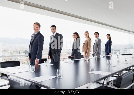 Portrait of smiling business people standing in a row at fenêtre salle de conférence Banque D'Images