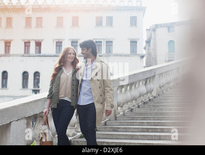 Smiling couple descending stairs à Venise Banque D'Images