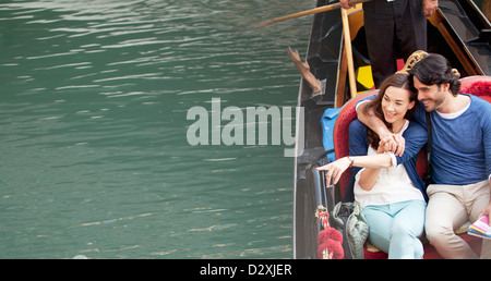 Smiling couple riding en gondole sur le canal à Venise Banque D'Images