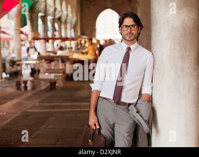 Portrait of businessman leaning against pilier à marché plein air Banque D'Images