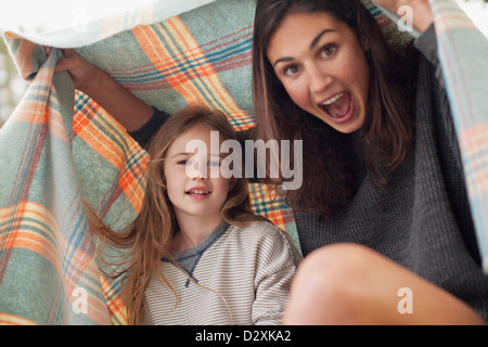 Mère et fille enthousiaste sous couverture Banque D'Images