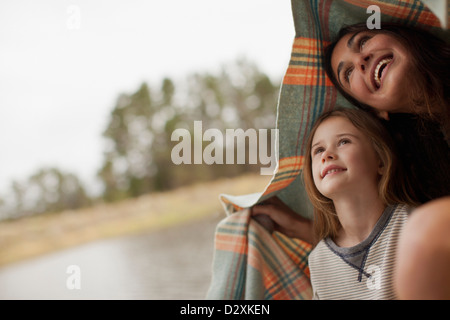 Smiling mother and daughter sous couverture à Lakeside Banque D'Images