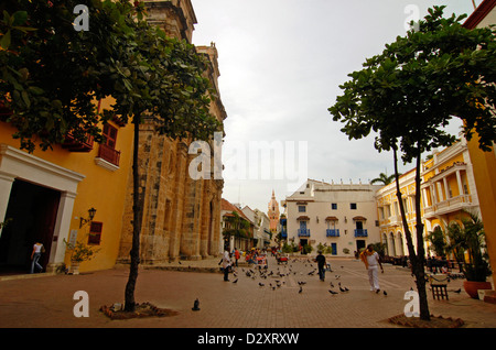 La Colombie, Cartagena, l'homme marche sur rue par église catholique avec des oiseaux en milieu de structure bâtie contre ciel clair Banque D'Images