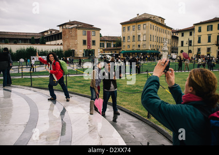 Les touristes ayant leurs photos prises à il tour de Pise dans la Piazza del Duomo, Italie Banque D'Images