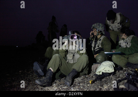 Une femme israélienne du 727th Eitam Field Intelligence Battalion du combat Intelligence Collection corps utilisant un Night Vision jumelles pendant l'entraînement à l'avance la nuit près de la frontière avec l'Égypte dans le sud du désert du Néguev en Israël Banque D'Images