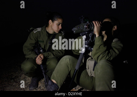 Une femme israélienne du 727th Eitam Field Intelligence Battalion du combat Intelligence Collection corps utilisant un Night Vision jumelles pendant l'entraînement à l'avance la nuit près de la frontière avec l'Égypte dans le sud du désert du Néguev en Israël Banque D'Images