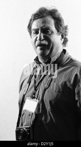 Photographe à une chemise à carreaux avec un insigne, noir et blanc Banque D'Images