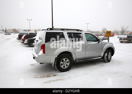 Voitures garées dans le stationnement du magasin dans l'espace réservé à la famille tempête de blizzard Saskatoon Saskatchewan Canada Banque D'Images