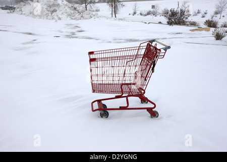 Chariot d'achat abandonné dans la neige couverts parking du supermarché Saskatoon Saskatchewan Canada Banque D'Images