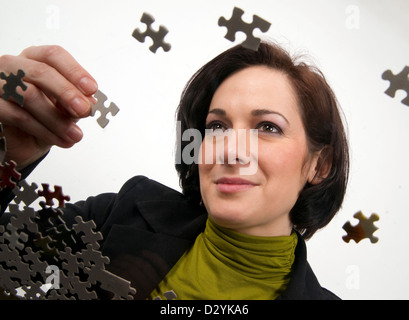 Femme tenant une pièce du puzzle Banque D'Images