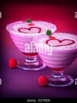 Photo de délicieux dessert de la Saint-Valentin dîner romantique, yogourt glacé, deux tasses en verre avec smoothie rose Banque D'Images