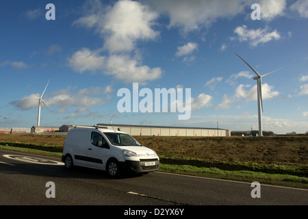 Une camionnette blanche roulant des yeux du passé industriel de nouvelles éoliennes Banque D'Images