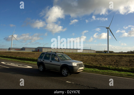 Une voiture roulant des yeux du passé industriel de nouvelles éoliennes Banque D'Images