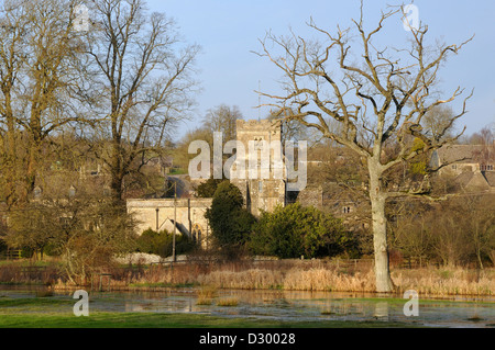 La fin de l'hiver soleil sur St James église normande et rivière Colne, Coln St Dennis, Gloucestershire Banque D'Images