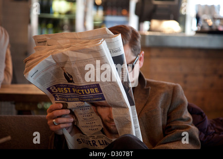 Un homme lisant le journal The Guardian. Banque D'Images