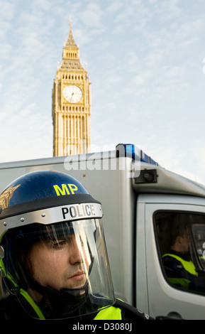Officier de police dans une émeute de démonstration casque manifestation à Londres, UK avec Big Ben derrière Banque D'Images