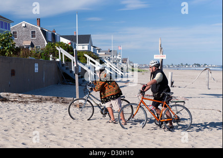 Senior couple poussant leurs vélos dans le sable. Moody Beach, Maine, USA. Banque D'Images