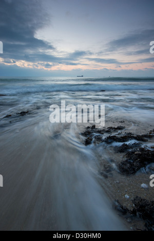 Vague se précipiter à la mer sur la plage de château à Falmouth au lever du soleil Banque D'Images