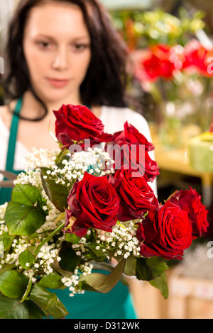 Jeune femme faisant un fleuriste bouquet de fleurs roses vendre Banque D'Images