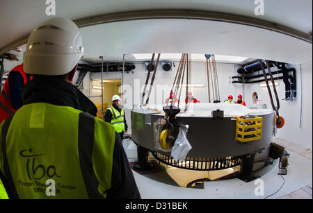 Installer un composant les travailleurs de plus de 220 tonnes d'un accélérateur de protons lourds sur une fondation dans le nouveau bâtiment du centre de radiothérapie de patients atteints de cancer 'Oncoray' sur le campus de l'université de médecine de Dresde, Allemagne, 06 février 2013. L'hôpital universitaire et l'Dresden-Rossendorf commune annoncée le même jour que les premiers patients sont prévus d'être traité au printemps 2014. Photo : ARNO BURGI Banque D'Images