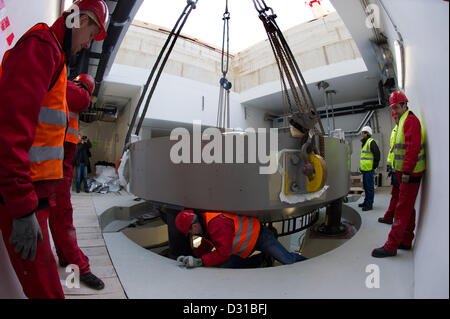 Installer un composant les travailleurs de plus de 220 tonnes d'un accélérateur de protons lourds sur une fondation dans le nouveau bâtiment du centre de radiothérapie de patients atteints de cancer 'Oncoray' sur le campus de l'université de médecine de Dresde, Allemagne, 06 février 2013. L'hôpital universitaire et l'Dresden-Rossendorf commune annoncée le même jour que les premiers patients sont prévus d'être traité au printemps 2014. Photo : ARNO BURGI Banque D'Images