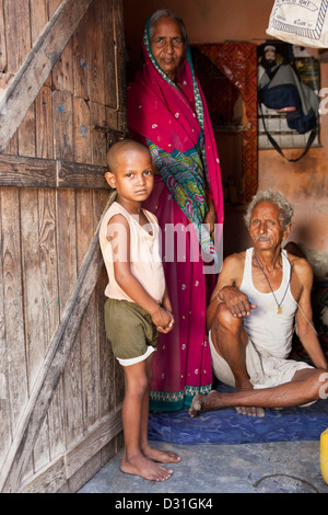 Jeune Indien enfant se tient à la porte de sa maison à Tehkhand Slum, Delhi, Inde. 8 membres de la famille vivent ici. Banque D'Images