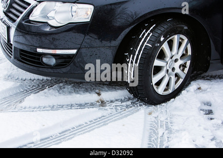 Voiture avec des pneus d'hiver sur une route avec la couverture de neige. Banque D'Images