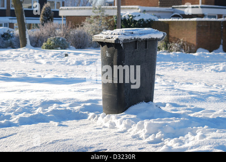 Une poubelle laissée dans la neige non collectées par le conseil en raison des conditions routières dangereuses et le manque de soins de saleuses du conseil Banque D'Images