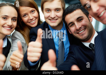 Portrait de cinq partenaires d'affaires et maintien de Thumbs up looking at camera with smiles Banque D'Images