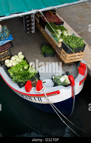 Un vendeur de fruits et légumes sur un bateau sur le Rio de San Barnaba le long de la Fondamenta Girardini et Ponte Dei Pugni, Dorsoduro, Venise, Italie. Banque D'Images