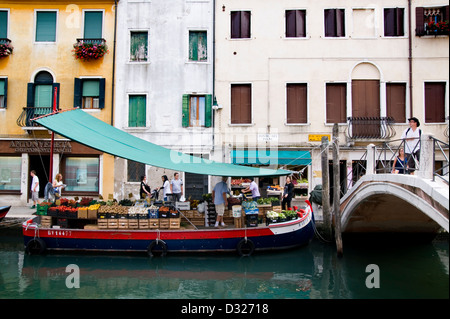 Un vendeur de fruits et légumes sur un bateau sur le Rio de San Barnaba le long de la Fondamenta Girardini et Ponte Dei Pugni, Dorsoduro, Venise, Italie. Banque D'Images