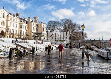 Les gens qui marchent le long de la rivière couverte de neige vers Richmond Bridge en hiver, Richmond upon Thames, Grand Londres, UK Banque D'Images