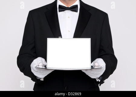 Butler holding a blank card sur un plateau de service en argent, ajouter votre propre message. Banque D'Images