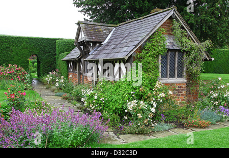 Le bâtiment à colombages connu sous le plateau Cottage dans l'arbuste Rose Garden à Arley Hall gardens Cheshire England UK Banque D'Images