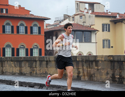 Un coureur italien aller sur le fleuve Arno via le pont Ponte Santa Trinita à Florence, Italie Banque D'Images