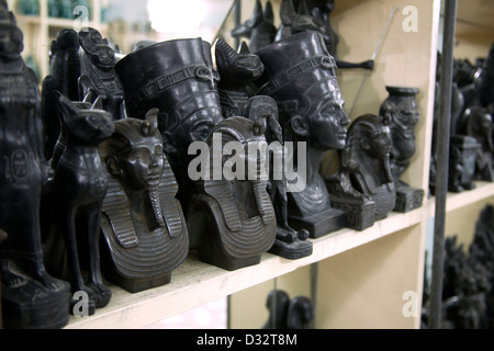 La sculpture sur pierre souvenirs de pharaons, des chats, des scarabées et des dieux en vente dans une boutique de cadeaux touristiques à Louxor Eqypt Banque D'Images