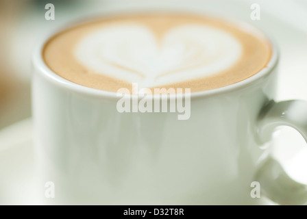 Petite tasse de café avec du lait dans la conception du cœur. Banque D'Images