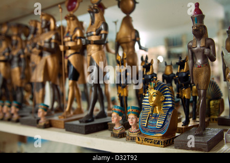 La sculpture sur pierre souvenirs de pharaons, des chats, des scarabées et des dieux en vente dans une boutique de cadeaux touristiques à Louxor Eqypt Banque D'Images