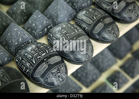 La sculpture sur pierre souvenirs de pharaons, des chats, des scarabées et des dieux en vente dans une boutique de cadeaux touristiques à Louxor Eqypt Banque D'Images