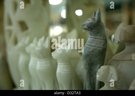 La sculpture sur pierre souvenirs de pharaons, des chats, des scarabées et des dieux en vente dans une boutique de cadeaux touristiques à Louxor Eqypt Banque D'Images