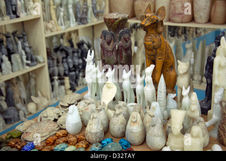 La sculpture sur pierre souvenirs de pharaons, des chats, des scarabées et des dieux en vente dans une boutique de cadeaux touristiques à Louxor Eqypt Banque D'Images