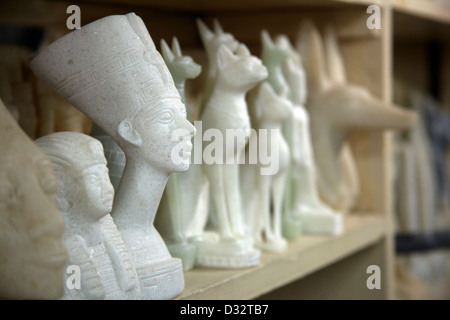 La sculpture sur pierre souvenirs de pharaons, des chats, des scarabées et des dieux en vente dans une boutique de cadeaux touristiques à Louxor Eqypt Banque D'Images