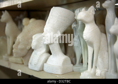 La sculpture sur pierre souvenirs de pharaons, des chats, des scarabées et des dieux en vente dans une boutique de cadeaux touristiques à Louxor Eqypt Banque D'Images