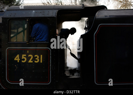 Fireman pelleter du charbon sur une locomotive à vapeur noir LMS 5 45231 great central railway loughborough england uk Banque D'Images