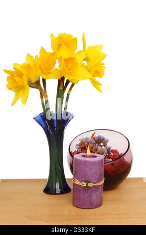 Les jonquilles, pot-pourri et la gravure bougie Feng Shui sur une table contre un fond blanc Banque D'Images