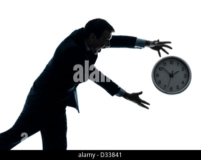 Un homme qui court après le temps en silhouette studio isolé sur fond blanc Banque D'Images