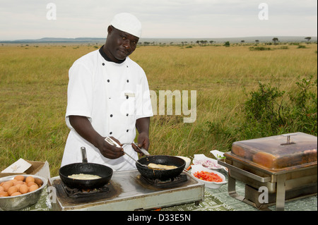 La préparation d'un chef petit-déjeuner bush, Maasai Mara National Reserve, Kenya Banque D'Images